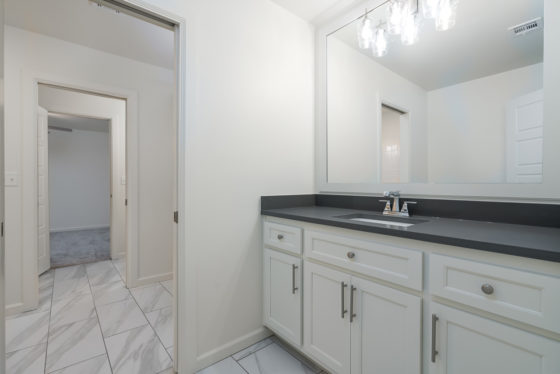 Bathroom with white cabinetry and dark countertop