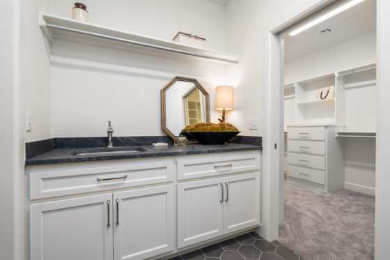 Laundry room counter with sink and adjoining primary closet